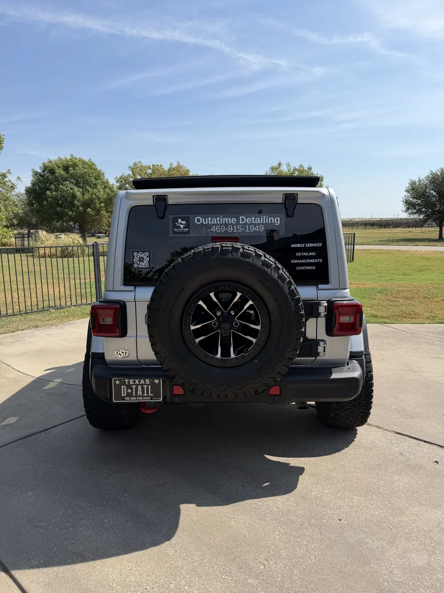 The OutaTime Detailing Jeep from behind, company name and phone number on the rear window