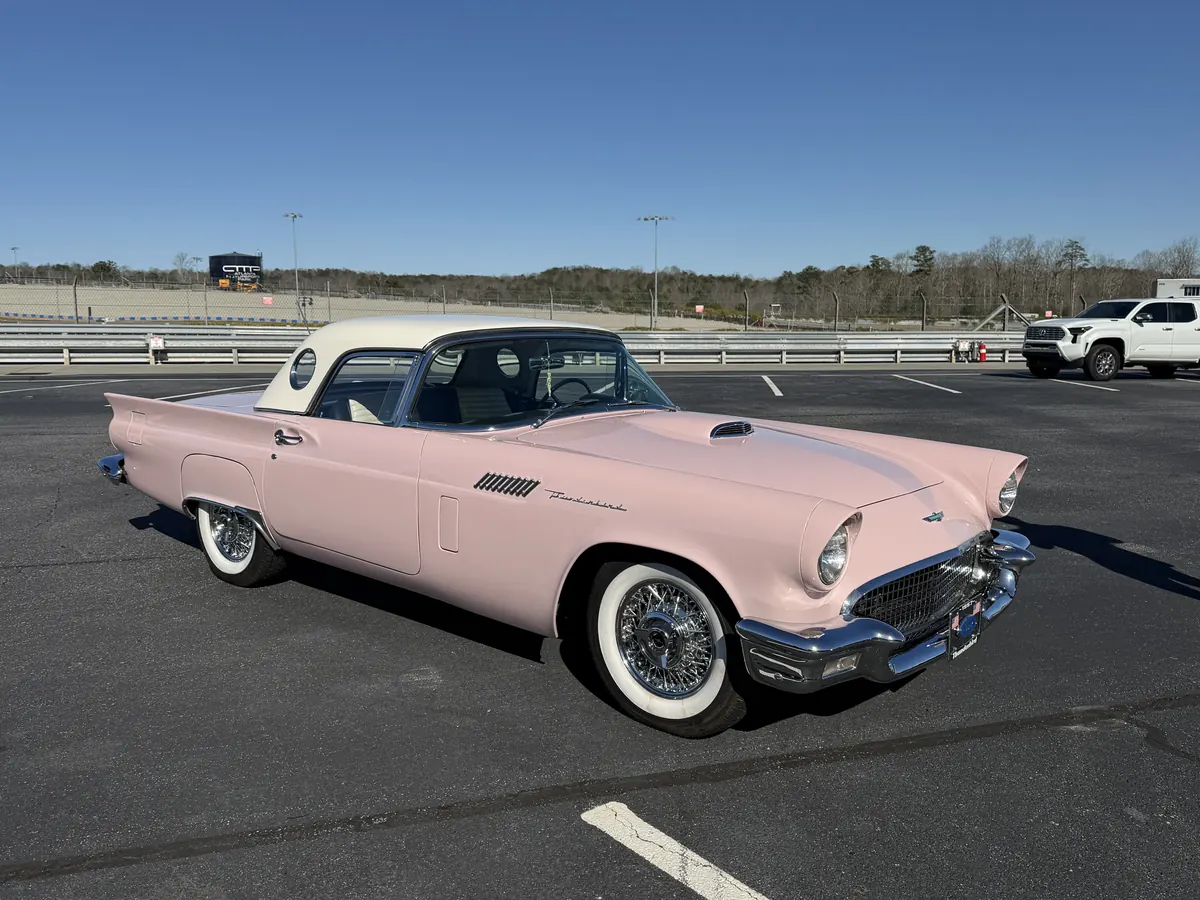 Classic pink Thunderbird with a white roof and whitewall tires