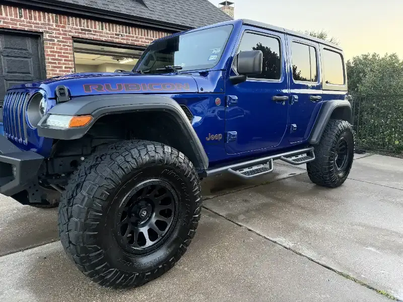 Lifted blue Jeep Wrangler Rubicon, front three-quarter view