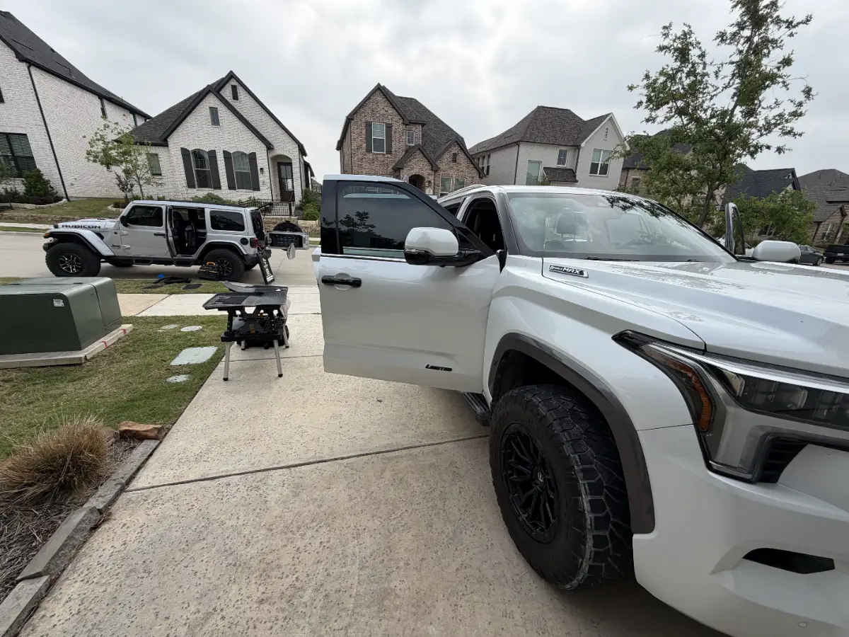 White pickup on a driveway with the OutaTime Jeep behind it