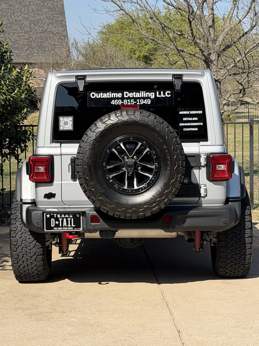 The OutaTime Detailing Jeep from behind, company name and phone number on the rear window